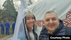 Украин блогер Василь Гончар (пан Василь) Киевтегі мызғымастық киіз үйінің алдында қазақ киімін киген қызбен бірге суретке түсіп тұр. Василь Гончардың жеке архиміндегі фото.