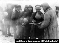 Крестьяне получают пшено на трудодни в колхозе имени Д. Бедного в с. Удачное Гришинского района Донецкой области Место и дата съемки: с. Удачное, 1930-е